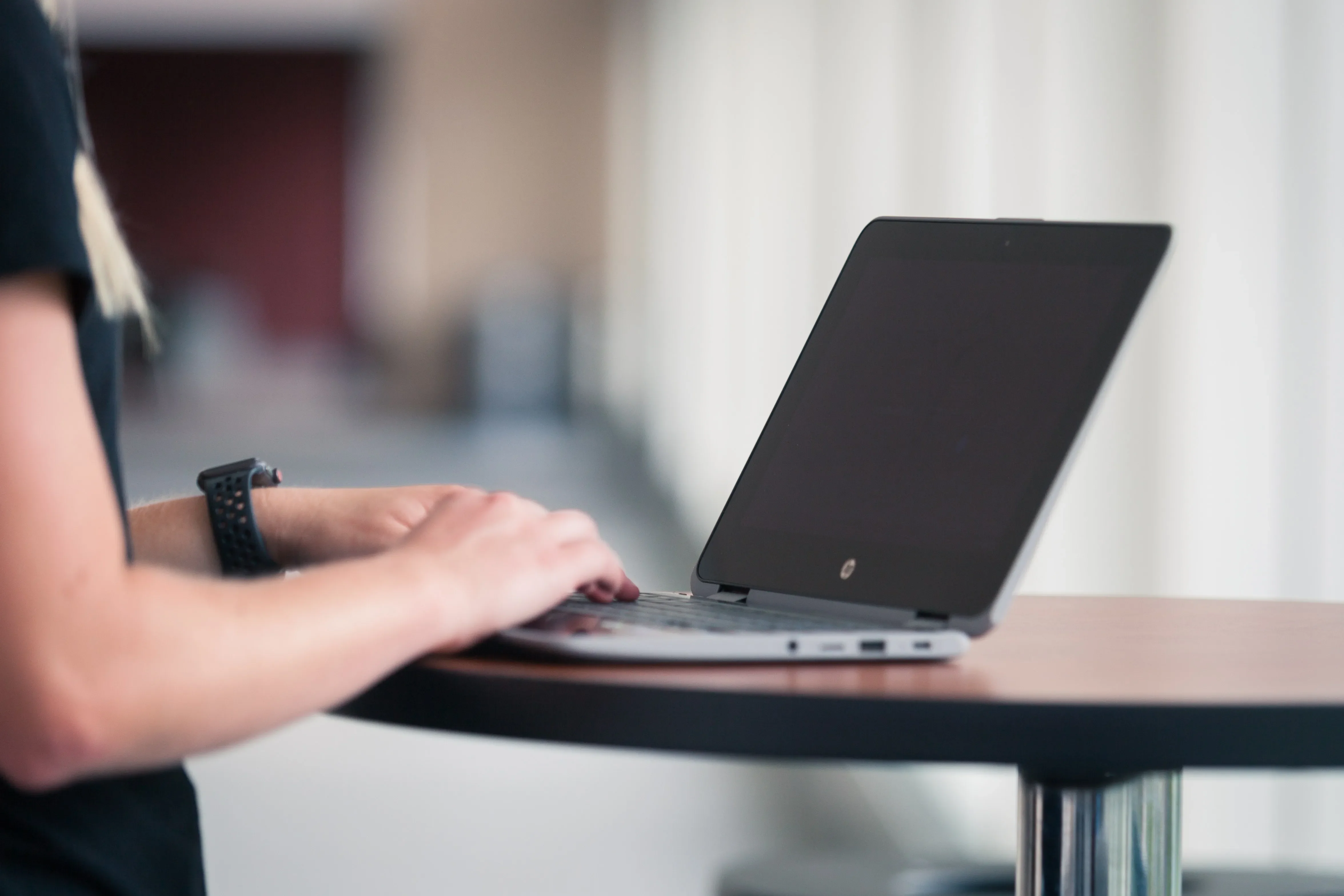 student with open laptop on brown table